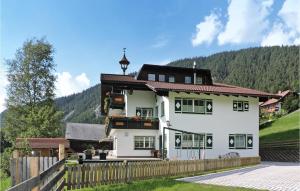 a large white house with a wooden fence at Amazing Apartment In Schladming With 2 Bedrooms And Internet in Gleiming
