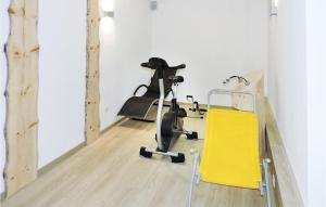 einen Fitnessraum mit einem Heimtrainer und einem gelben Stuhl in der Unterkunft 2 Bedroom Gorgeous Apartment In Schladming in Gleiming