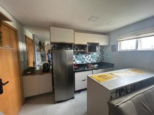 eine Küche mit einem Kühlschrank aus Edelstahl und einer Theke in der Unterkunft Mi casa Su Casa Apartment Studio 1 a 4 pessoas in Curitiba
