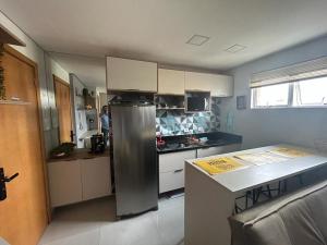 a kitchen with a stainless steel refrigerator and a counter at Mi casa Su Casa Apartment Studio 1 a 4 pessoas in Curitiba +11 photos