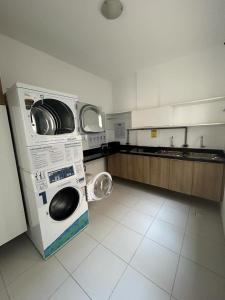 a kitchen with a washing machine in a kitchen at Mi casa Su Casa Apartment Studio 1 a 4 pessoas in Curitiba