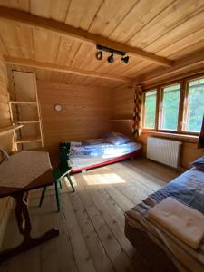 a room with a bed and a desk in a cabin at Dom na końcu świata in Ochotnica Górna
