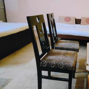 una sedia in legno seduta in una stanza con un letto di HOTEL CASTLE HOME STAY a Jaipur