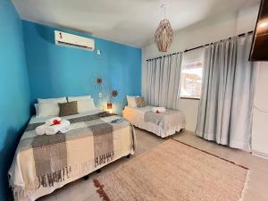 1 dormitorio con 2 camas y pared azul en Pousada Nascente do Sol, en Isla de Boipeba