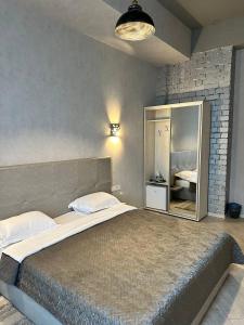 - une chambre avec un grand lit et un miroir dans l'établissement Hotel Nika 2, à Tchornomorsk