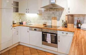 a kitchen with white cabinets and a stove top oven at Cozy Home In Bad Waltersdorf With Sauna in Bad Waltersdorf
