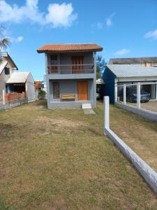 uma casa com um quintal em frente em Casa de Praia - Frente para o MAR em Xangri-lá