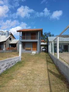 ein Haus mit einem Zaun davor in der Unterkunft Casa de Praia - Frente para o MAR in Xangri-lá