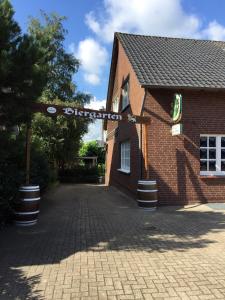 un bâtiment en briques avec un panneau de rue devant lui dans l'établissement Venner Gasthaus, à Ostercappeln