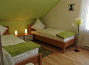 1 dormitorio con 2 camas, paredes verdes y una flor en Venner Gasthaus, en Ostercappeln