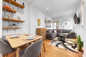 a living room with a table and a couch at Modern Spacious 1 Bed Flat near Richmond Park in London