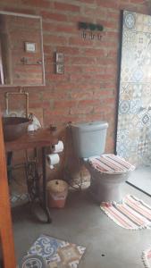 a bathroom with a toilet and a sink at Chalé charmoso com vista p/ Montanha - Gonçalves in Paraisópolis