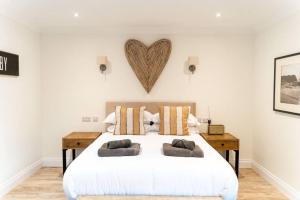 a bedroom with a large white bed with a heart on the wall at Hideaway Cottages - Greenacres Estates in Tenby