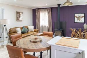 a living room with a table and a couch at Hideaway Cottages - Greenacres Estates in Tenby