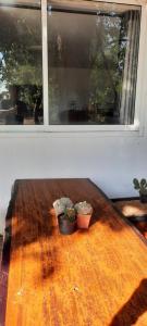 zwei Töpfe auf einem Holztisch vor einem Fenster in der Unterkunft โฮมสเตย์แม่ปราณี4 
