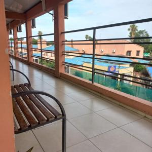 un banc sur un balcon avec vue sur la piscine dans l'établissement Hotel Marcos Dayman, à Termas del Daymán