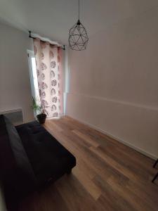 an empty living room with a couch and a window at Appart T3 à Pamiers in Pamiers