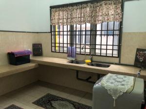 een badkamer met een wastafel en een raam met een wastafel bij Padusi Homestay in Kampar