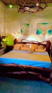 a bedroom with a large bed with blue sheets at SD3M ART GALLERY Villa in Dickwella