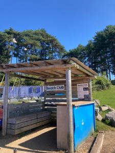 a wooden bus stop with a sign on it at Rockley Park in Lytchett Minster