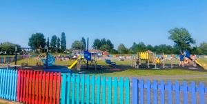 una valla colorida frente a un parque infantil en Rockley Park, en Lytchett Minster
