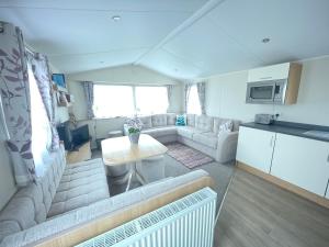 a living room with a couch and a table at Rockley Park in Lytchett Minster