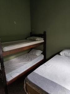 2 stapelbedden in een groene kamer met 2 matrassen bij Espaço Casa Branca in Caraguatatuba