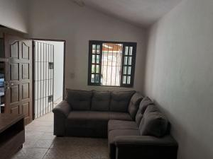 een woonkamer met een bank en een raam bij Espaço Casa Branca in Caraguatatuba