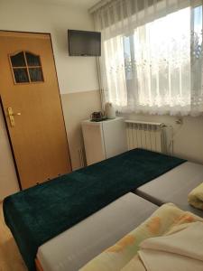 ポランチクにあるDG EWA w Polańczykuのベッド2台、ドア、窓が備わる客室です。