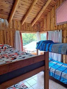 a bedroom with two beds in a wooden cabin at Cabañas La Terraza in El Bolsón +31 photos