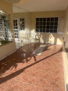 a house with a patio and a shadow on the floor at Portmore Havens 1Bedroom EntireGuest House in Portmore