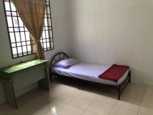 a small bedroom with a small bed and a window at Padusi Homestay in Kampar