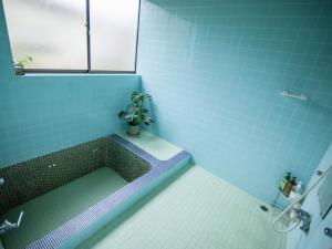 uma casa de banho com uma banheira com um vaso de plantas em Sakurasou Lodge em Nozawa Onsen