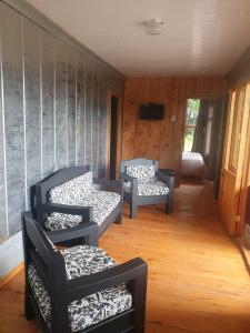 ein Wohnzimmer mit 2 Stühlen und einem Sofa in der Unterkunft Casa Monte Armadillo in Poás