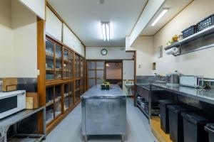 a large kitchen with stainless steel counter tops at Sakurasou Lodge in Nozawa Onsen
