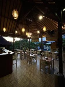 um restaurante com mesas e cadeiras de madeira e luzes em Taman Sari Villa, Nusa Lembongan em Nusa Lembongan