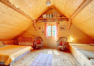 a bedroom with a bed and chairs in a attic at Chaloupka Malá Morávka in Malá Morávka