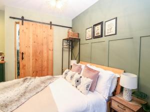 a bedroom with a bed and a wooden door at Goldcrest Hide in Bungay