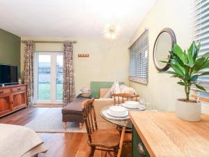 a living room with a table and a couch at Goldcrest Hide in Bungay