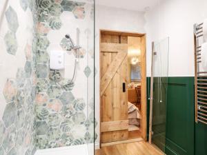 a bathroom with a shower with a glass door at Goldcrest Hide in Bungay