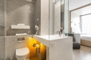 a bathroom with a toilet, sink and tub at Sound Garden Hotel Airport in Warsaw