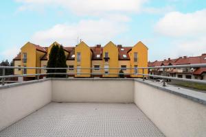 einen Balkon mit gelben Häusern im Hintergrund in der Unterkunft Dom Sianowska 130 m2, Parking & 3 Balkony Poznań by Renters in Posen