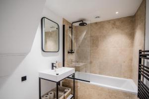 a bathroom with a sink and a bath tub at Lowen Tree House in Truro +58 photos