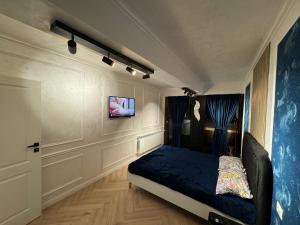 um quarto com uma cama e uma televisão na parede em FancyLux Apartament em Suceava