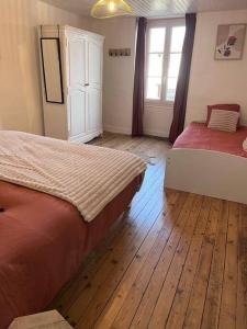 1 dormitorio con 2 camas y suelo de madera en Le temps suspendu - Futuroscope, en Jaunay-Clan