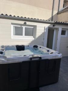 una bañera de hidromasaje al aire libre de una casa en Le temps suspendu - Futuroscope, en Jaunay-Clan