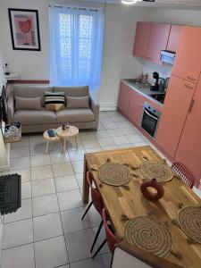 a kitchen and dining room with a table and a couch at Le temps suspendu - Futuroscope in Jaunay-Clan