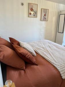 un sofá marrón con almohadas encima en Le temps suspendu - Futuroscope, en Jaunay-Clan