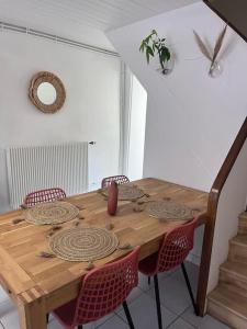 una mesa de madera en una habitación con sillas alrededor en Le temps suspendu - Futuroscope, en Jaunay-Clan