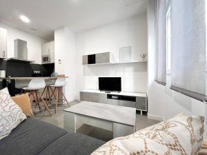 een witte woonkamer met een bank en een tafel bij Studio Alboránn in Málaga